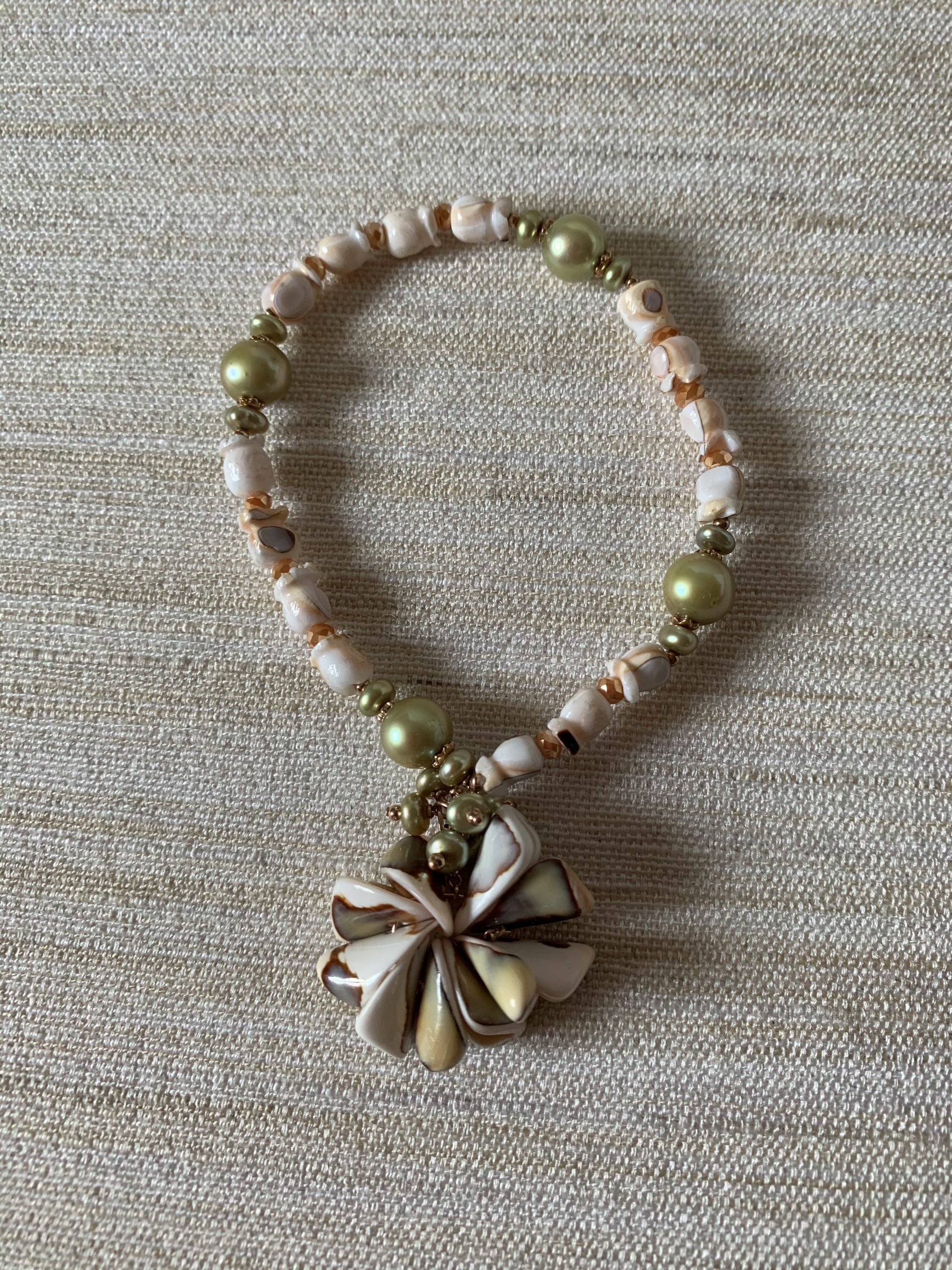 Bracciale elastico conchiglia, perle verdi e argento placcato oro rosa