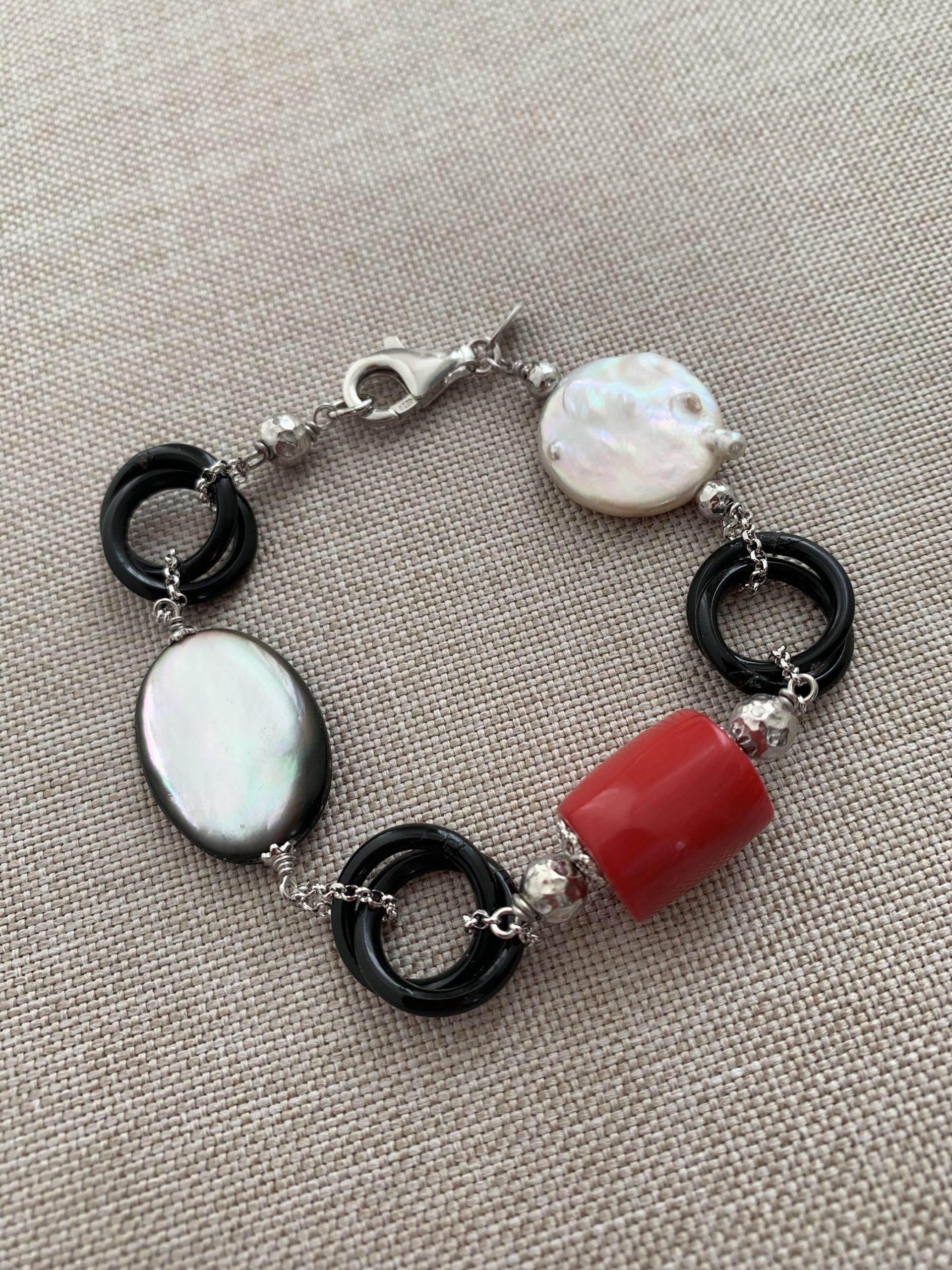 Bracciale incatenato con elementi di madreperla grigia, corno, corallo bamboo, perle coltivate e argento rodiato