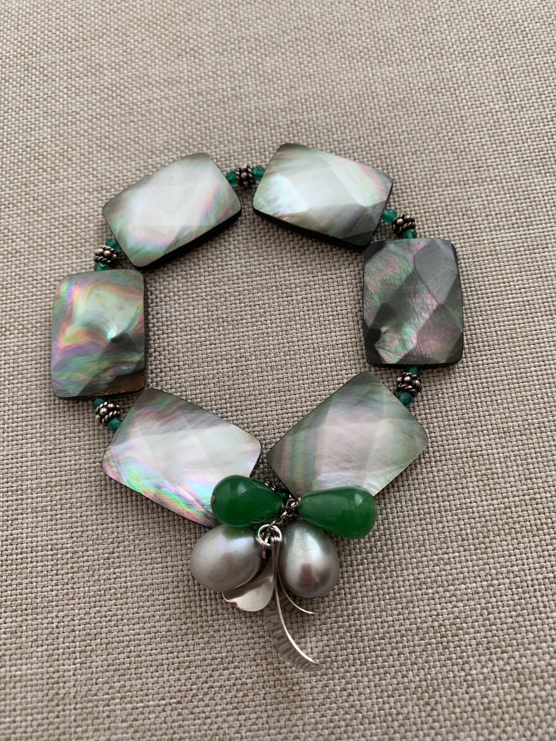 Bracciale elastico con rettangoli sfacettati di madreperla grigia, perle grigie, candy jade verde e argento rodiato