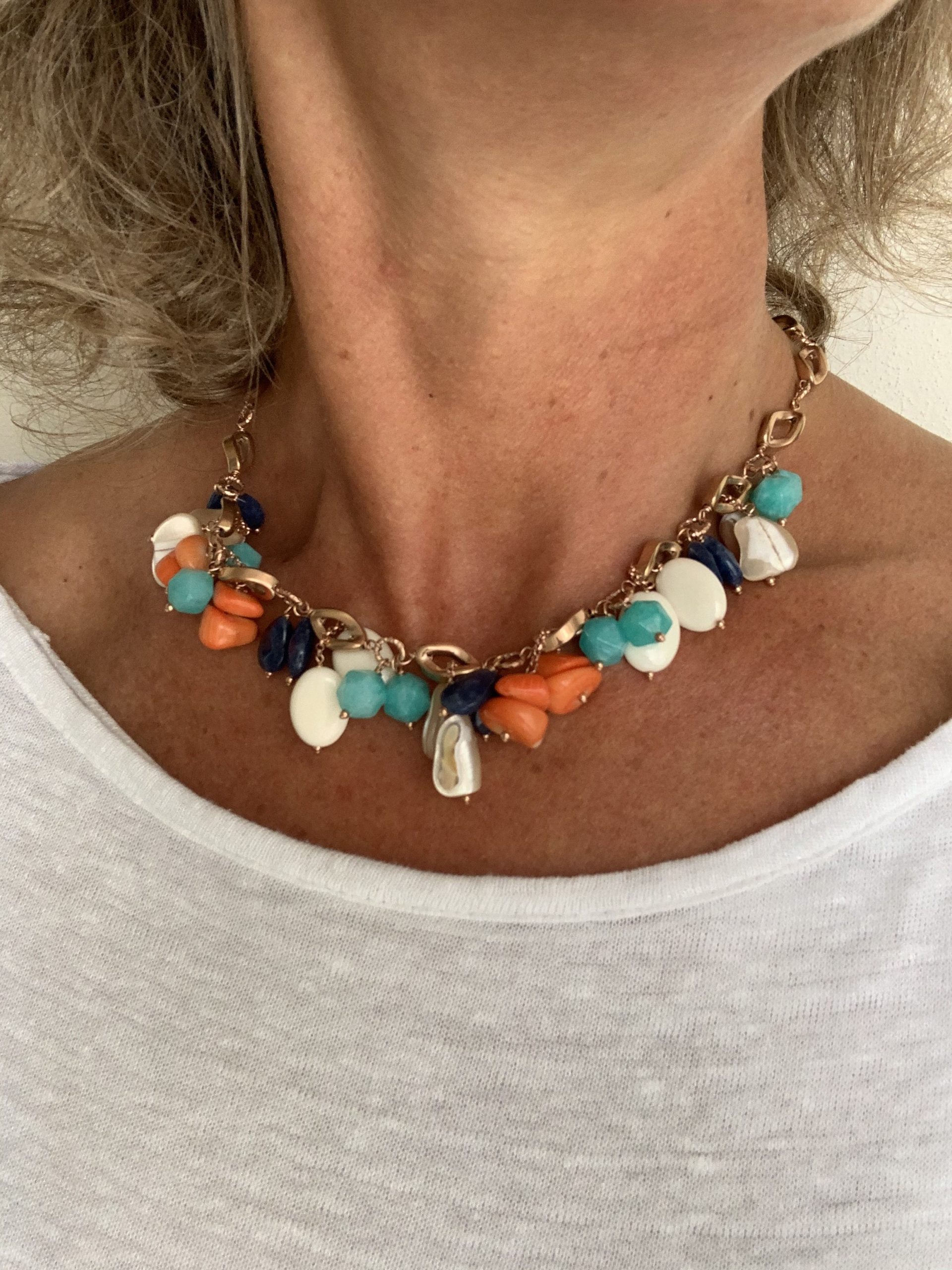 Girocollo di ematite rosa con cionodoli di osso, corallo, madreperla, quarzo blu e verde, in argento placcato oro rosa
