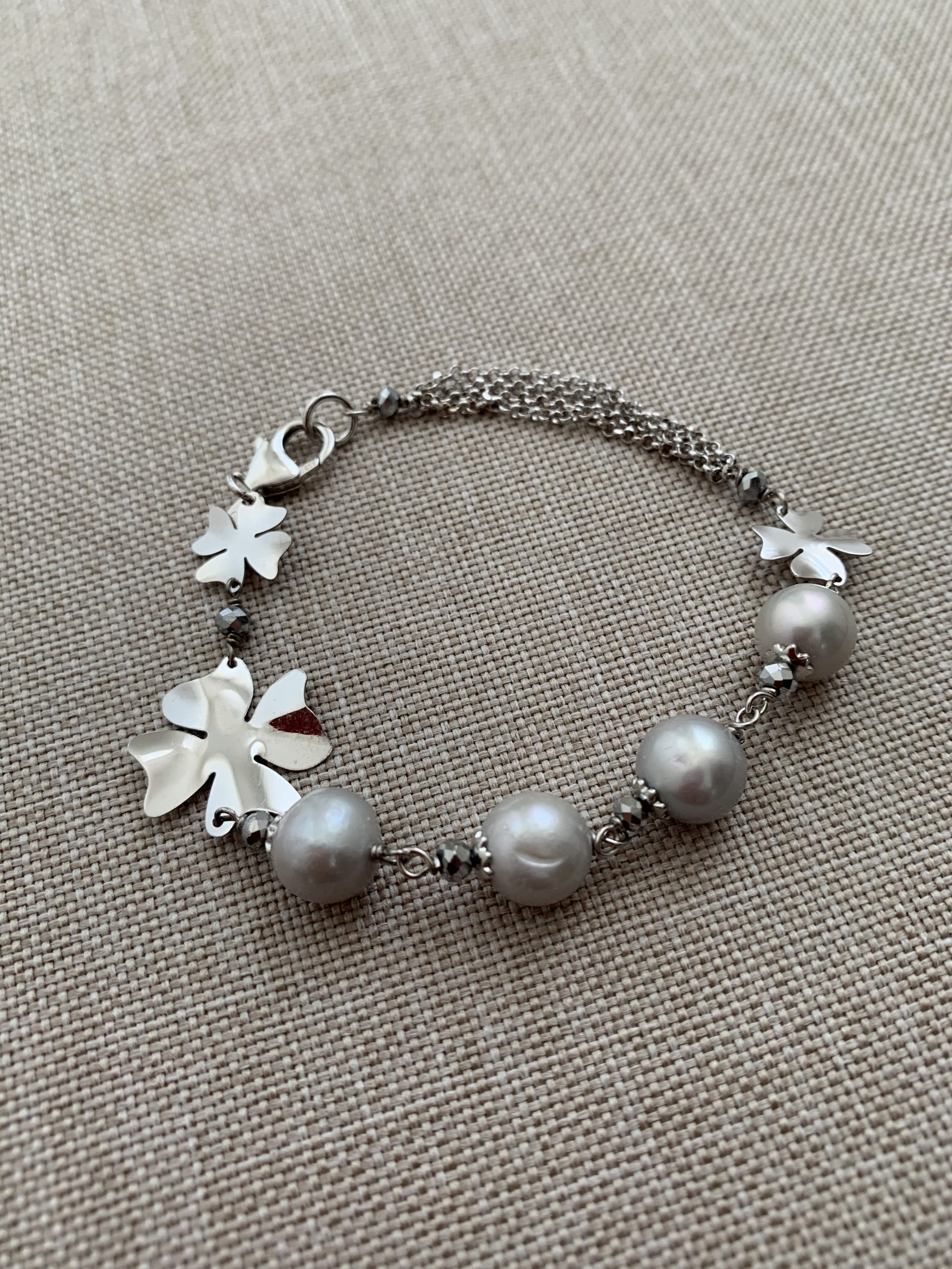 Bracciale di perle grigie con quadrifogli e catena d'argento rodiato