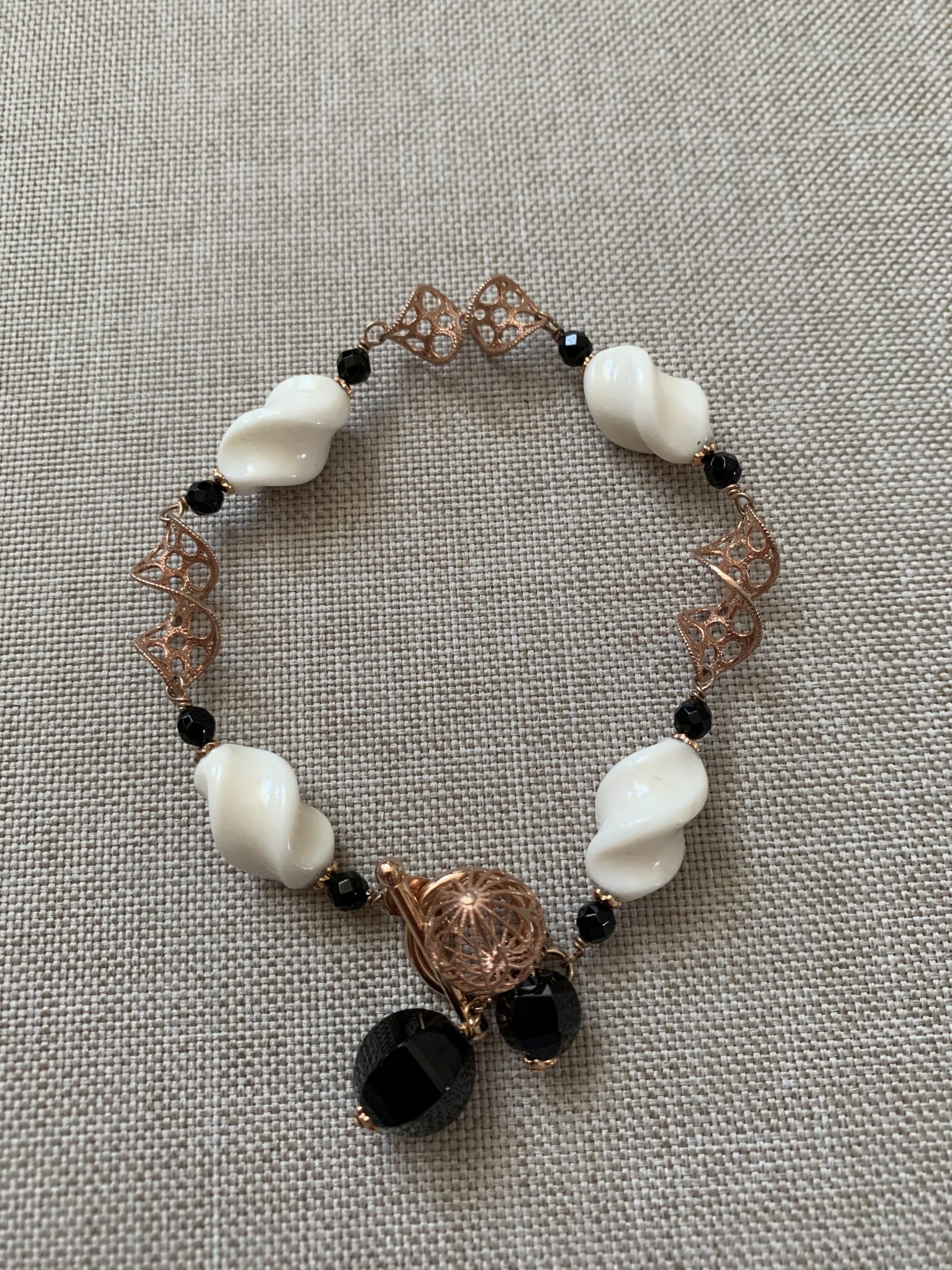 Bracciale con tortiglioni di osso, agata nera e argento placcato oro rosa