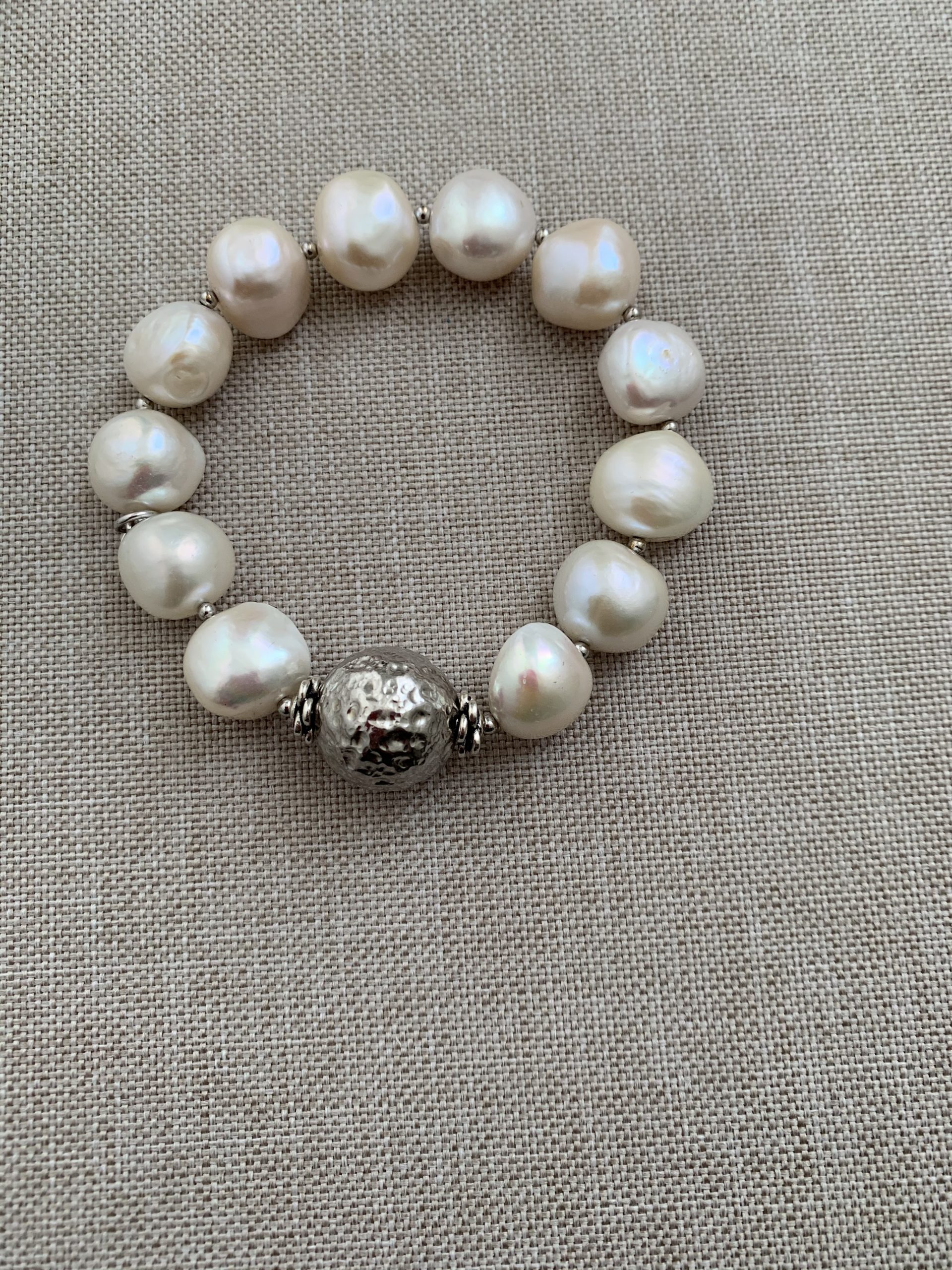 Bracciale elastico perle bianche con sfera martellata di argento rodiato