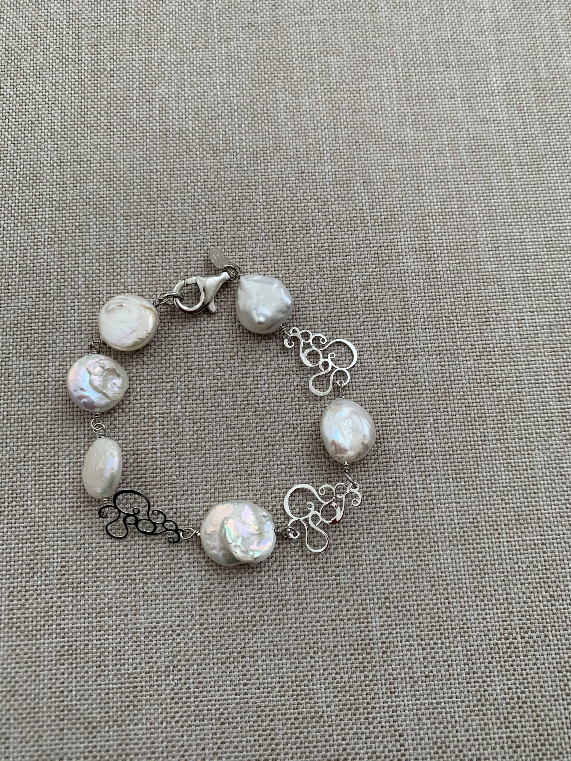 Bracciale incatenato con elementi di argento rodiato e perle bianche