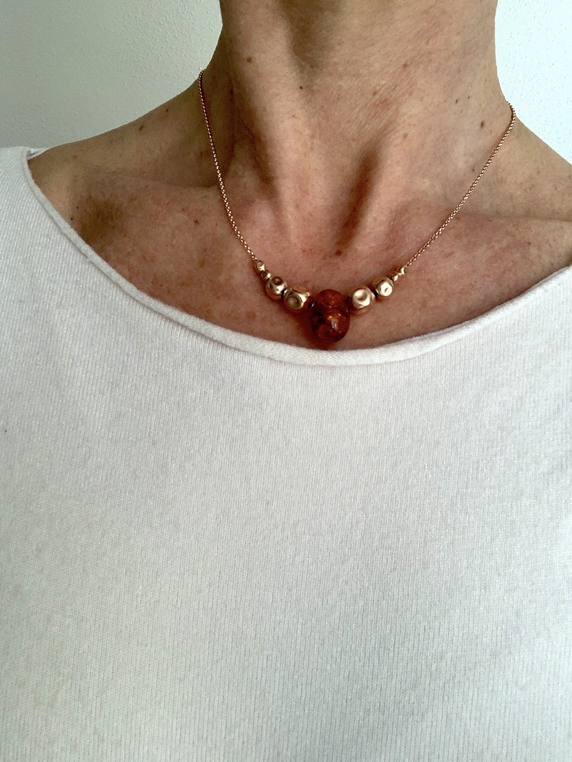 Catenina in argento placcato oro rosa con uovo di ambra sfaccettata